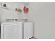 Clean laundry room equipped with modern washer and dryer units and storage shelving at 213 Hideaway Beach Ln, Kissimmee, FL 34746