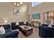 Sunlit living room showcasing comfortable seating, media console, and large windows at 213 Hideaway Beach Ln, Kissimmee, FL 34746