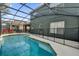 Backyard pool with safety fence surrounded by a screened enclosure at 213 Hideaway Beach Ln, Kissimmee, FL 34746