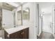 Bathroom featuring a wooden vanity, a framed mirror, and a view to a hallway and adjacent rooms at 2309 Sun Valley Cir # 2309, Winter Park, FL 32792