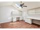 Bedroom featuring built-in desks with storage, ceiling fan, skylight, and hardwood floors at 2309 Sun Valley Cir # 2309, Winter Park, FL 32792