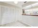 Open kitchen area with white cabinets and appliances, next to a storage area with white louvered doors at 2309 Sun Valley Cir # 2309, Winter Park, FL 32792