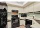 Efficient kitchen with sleek black appliances and ample cabinet space at 237 S Wilderness Pt, Casselberry, FL 32707