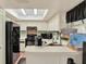 Kitchen featuring skylight, sleek black appliances, and ample counter space at 237 S Wilderness Pt, Casselberry, FL 32707