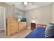 Bright bedroom with wood-look floors, ceiling fan and large dressers with TV at 239 Hill St # 239, Casselberry, FL 32707