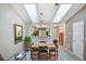 Bright dining area with skylights, modern chandelier, and stylish wood-look flooring, adjoining to kitchen at 239 Hill St # 239, Casselberry, FL 32707
