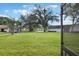 Lush front yard with mature trees providing shade and curb appeal, as seen from the screen door at 239 Hill St # 239, Casselberry, FL 32707