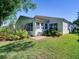 Charming home exterior with a cozy patio and lush landscaping, set against a vibrant green lawn at 25307 La Grange Ct, Leesburg, FL 34748