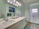 Bathroom with dual sinks, modern vanity, painting, and walk-in shower showcasing bright space at 25307 La Grange Ct, Leesburg, FL 34748