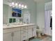 Bathroom with dual sinks, modern vanity, painting, and walk-in shower showcasing bright space at 25307 La Grange Ct, Leesburg, FL 34748
