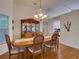 Elegant dining room featuring a classic chandelier, wood china cabinet, and natural light through windows at 25307 La Grange Ct, Leesburg, FL 34748