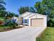 Charming single-story home with a well-manicured lawn, neutral exterior, and a two-car garage at 25307 La Grange Ct, Leesburg, FL 34748