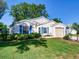 Attractive single-story home with an attached garage, blue shutters and well-maintained landscaping at 25307 La Grange Ct, Leesburg, FL 34748