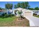 Inviting single-story home featuring blue shutters, a lush green lawn, and a paved driveway at 25307 La Grange Ct, Leesburg, FL 34748
