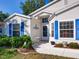 Charming entrance with blue shutters, a small seating area, and decorative landscaping at 25307 La Grange Ct, Leesburg, FL 34748