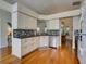 Modern kitchen featuring white cabinets, stainless steel appliances, and stylish backsplash at 25307 La Grange Ct, Leesburg, FL 34748