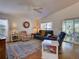 Bright living room with comfortable seating, ceiling fan, and sliding glass doors to the outdoor area at 25307 La Grange Ct, Leesburg, FL 34748