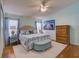 Bright and airy main bedroom with hardwood floors, ceiling fan, and natural light from the windows at 25307 La Grange Ct, Leesburg, FL 34748