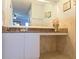 A bathroom vanity is displayed with white cabinets, granite countertop, and decorative tile work at 2812 Club Cortile Cir # A, Kissimmee, FL 34746