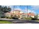 Stunning exterior view of clubhouse with stone accents and red roof at 2812 Club Cortile Cir # A, Kissimmee, FL 34746