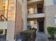 Exterior shot of a condo building entrance with a dark wood door and manicured bushes at 2812 Club Cortile Cir # A, Kissimmee, FL 34746