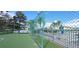 A community tennis court surrounded by a green fence, with a lake in the background at 2812 Club Cortile Cir # A, Kissimmee, FL 34746