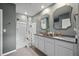 Bathroom with double vanity, framed mirrors, and a shower-tub combo with patterned shower curtain at 2900 Sunridge Loop, St Cloud, FL 34771