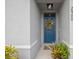 Inviting entryway featuring a blue front door with a decorative wreath and potted plants at 2900 Sunridge Loop, St Cloud, FL 34771