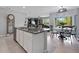 Spacious kitchen island with granite countertops and stainless steel appliances overlooking the adjacent living and dining area at 2900 Sunridge Loop, St Cloud, FL 34771