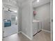 View from a bedroom into a gray laundry room with modern, white appliances at 2900 Sunridge Loop, St Cloud, FL 34771
