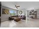 Bright living room with large window, ceiling fan, and comfortable leather sofa at 2900 Sunridge Loop, St Cloud, FL 34771