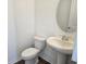 Half bathroom featuring a modern sink, toilet, and decorative mirror at 2980 Embark Trail, St Cloud, FL 34771