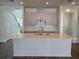 Modern kitchen with white cabinets, subway tile backsplash, an island, and hardwood floors at 2980 Embark Trail, St Cloud, FL 34771