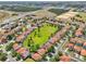 Expansive aerial showcasing orange tile roofs surrounded by lush landscaping in a suburban neighborhood at 332 Summer Place Loop, Clermont, FL 34714