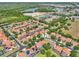 A neighborhood with orange tile roofs is nestled between roads, lakes, and woodlands at 332 Summer Place Loop, Clermont, FL 34714