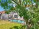 Lush backyard with a pool and screened in patio partially obstructed by a tree at 332 Summer Place Loop, Clermont, FL 34714