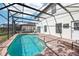 Outdoor pool featuring a brick pool deck with screened enclosure and a grassy lawn at 332 Summer Place Loop, Clermont, FL 34714