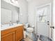 Well-lit bathroom with wood vanity, toilet, and exterior door with window at 332 Summer Place Loop, Clermont, FL 34714