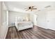 A neutral bedroom featuring hardwood floors, a ceiling fan, and a large white bed at 332 Summer Place Loop, Clermont, FL 34714