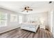 The bedroom features hardwood floors, a ceiling fan, and a large white bed at 332 Summer Place Loop, Clermont, FL 34714