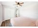 Bedroom with wood-look flooring, ceiling fan, walk-in closet, pink bedding, and neutral colored walls at 332 Summer Place Loop, Clermont, FL 34714