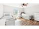 Bedroom with hardwood floors, ceiling fan, white walls, two twin beds, and matching bedside tables at 332 Summer Place Loop, Clermont, FL 34714