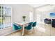 Bright dining area features a marble table, teal chairs, and large window overlooking the pool at 332 Summer Place Loop, Clermont, FL 34714