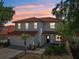 Two-story home at dusk featuring a red tile roof and well-maintained landscaping at 332 Summer Place Loop, Clermont, FL 34714