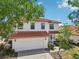 Two-story home with red tile roof, two-car garage, and nicely landscaped front yard at 332 Summer Place Loop, Clermont, FL 34714