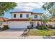 Inviting two-story home featuring a tile roof, a spacious two-car garage, and a well-kept lawn at 332 Summer Place Loop, Clermont, FL 34714