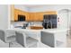 Kitchen bar with seating overlooking stone countertops and stainless steel appliances and light wood cabinetry at 332 Summer Place Loop, Clermont, FL 34714