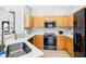 Well-equipped kitchen with stainless steel appliances and light wood cabinetry and stone countertops at 332 Summer Place Loop, Clermont, FL 34714