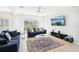 Bright living room with tile floors, ceiling fan, comfortable sofas, and sliding glass doors to pool area at 332 Summer Place Loop, Clermont, FL 34714