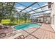 Inviting pool area with brick patio, lounge chairs, and screened enclosure at 332 Summer Place Loop, Clermont, FL 34714